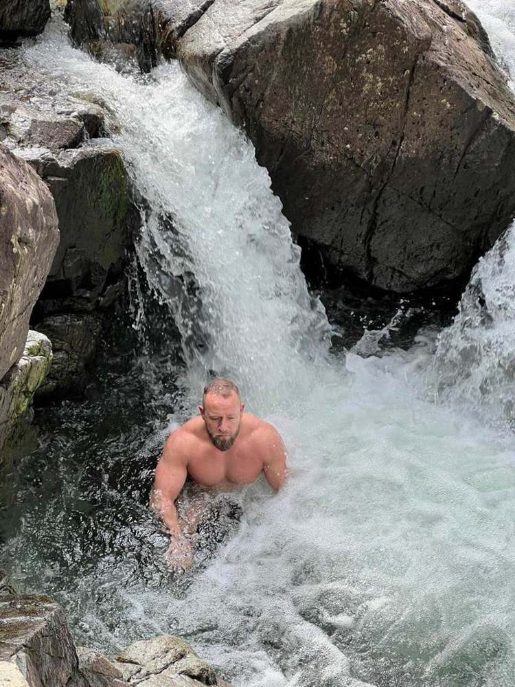 A walker under a waterfall in the Lake District